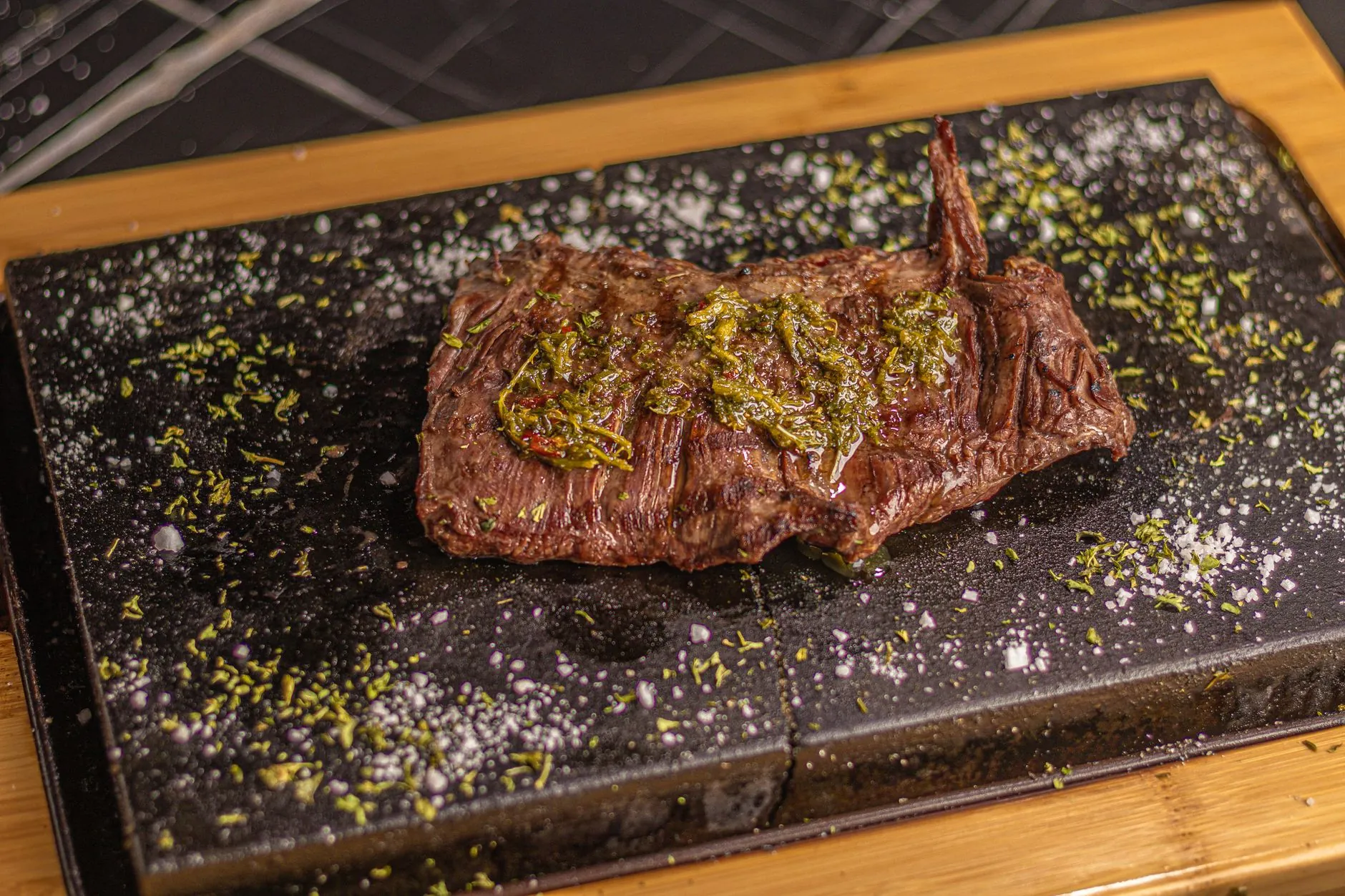 Bife sobre una piedra negra con hierbas y sal